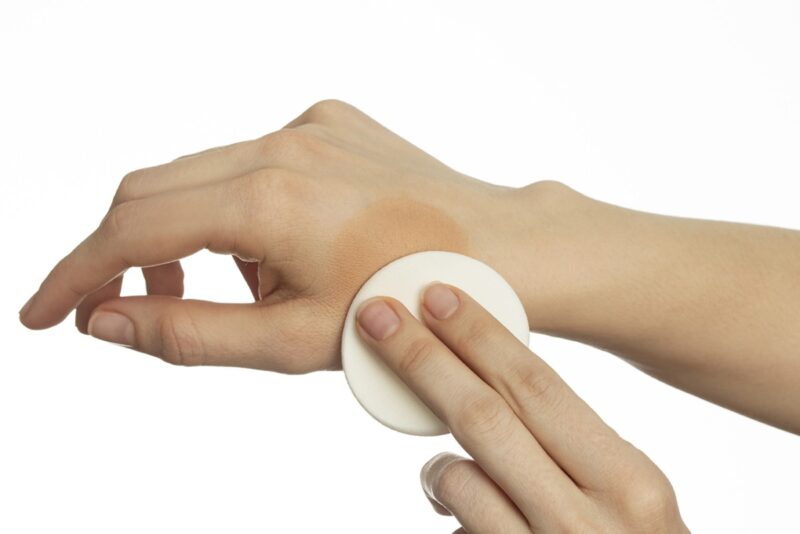 Demonstratie van Heliocare 360° Oil-free Compact SPF50+ Bronze applicatie op de huid met zichtbare kleurpigmenten